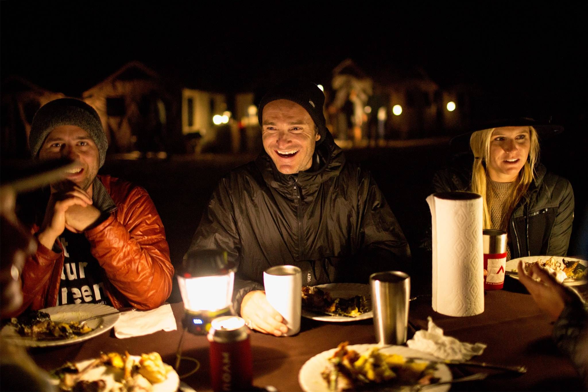 Three people enjoying dinner at a picnic table