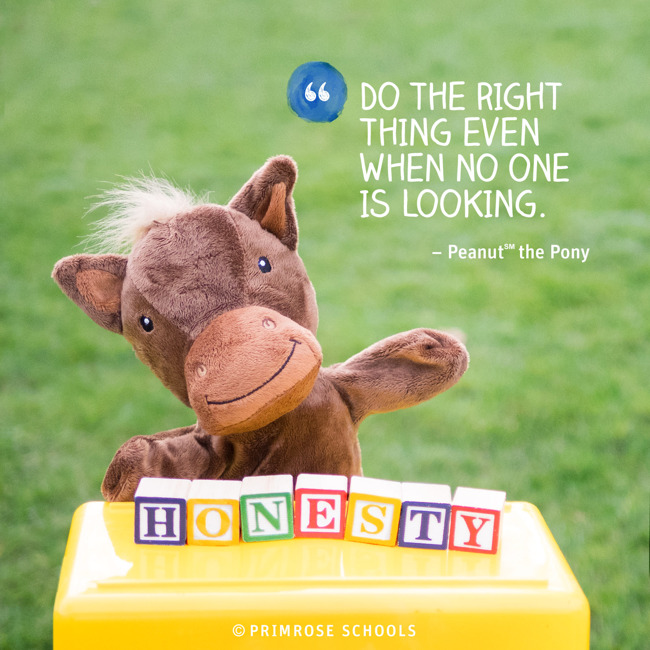 Peanut the pony hand puppet stands behind block that spell the word "Honesty"