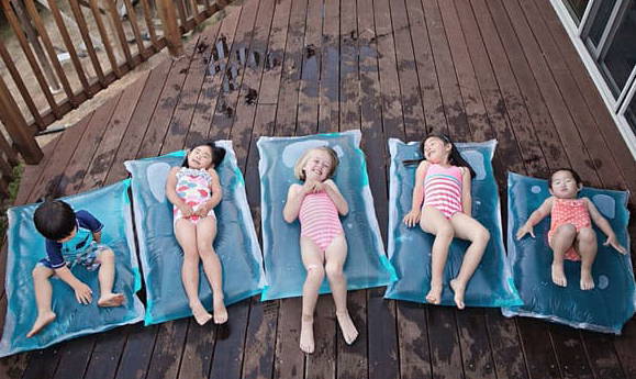 Kids laying on large bags full of water