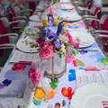 colorful printed tablecloth with flowers and plates over it