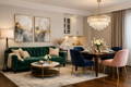 green velvet sofa in a luxurious room with a square dinner table with velvet chairs