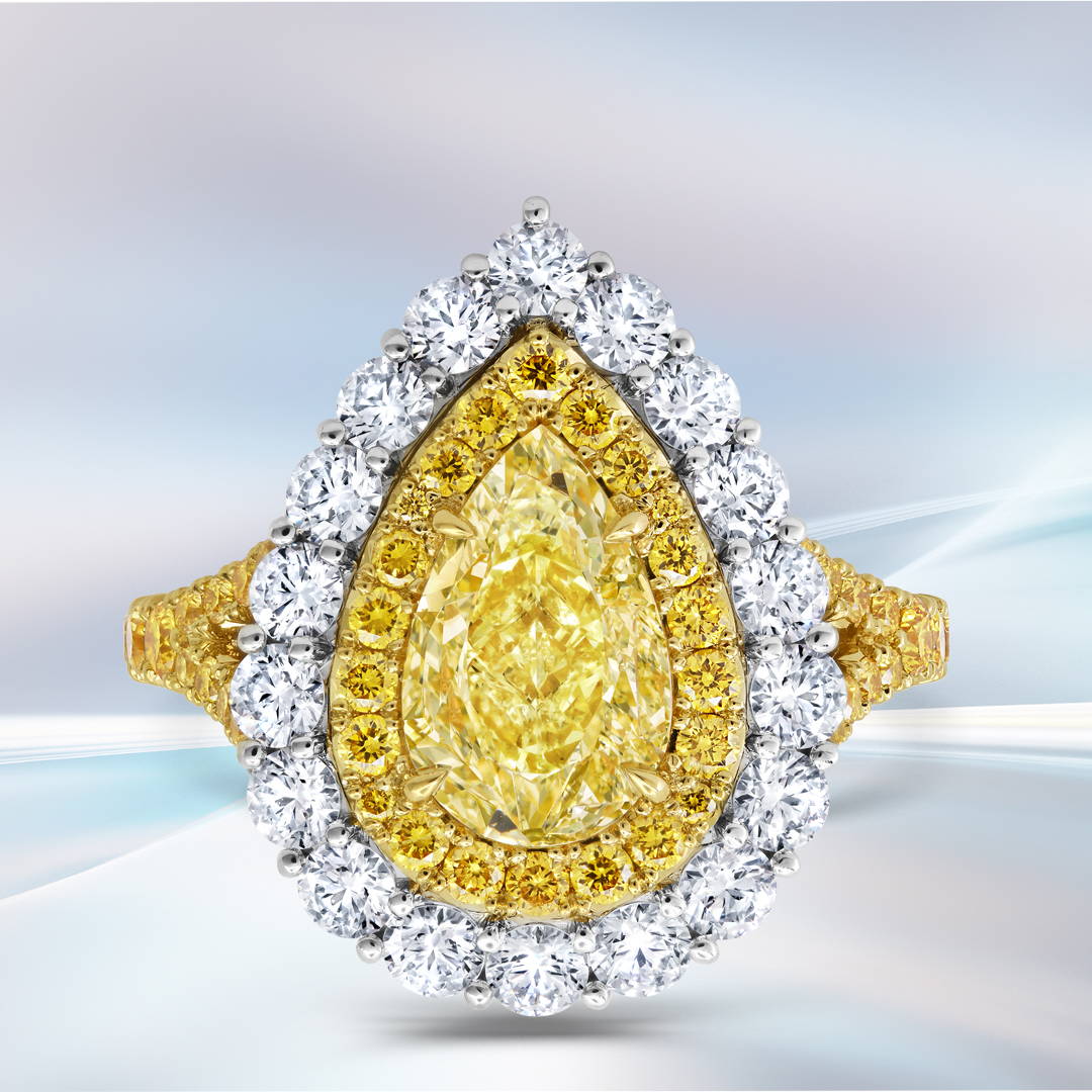 Pear shaped Yellow Diamond ring with white diamonds in platinum and yellow gold