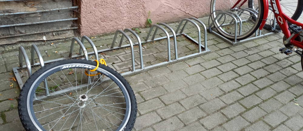 Bike rack with stolen bike and remaining wheel