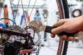 Gros plan sur les freins d'un vélo et les outils d'un mécanicien qui va s'en occuper