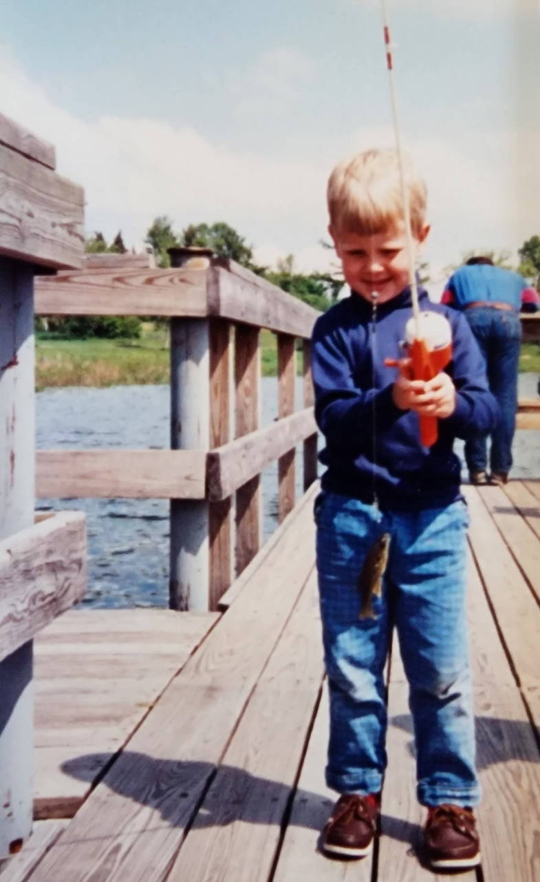 A child fishing from a wooden dock