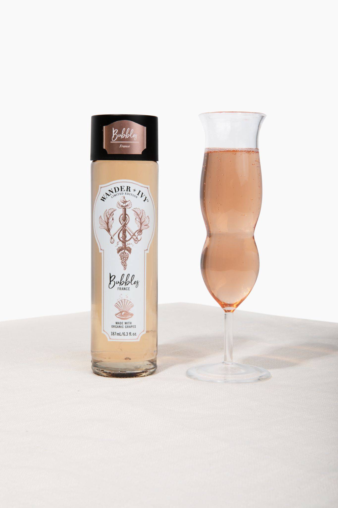 Two single-serve bottles of Sauvignon Blanc next to an apple and a filled wine glass