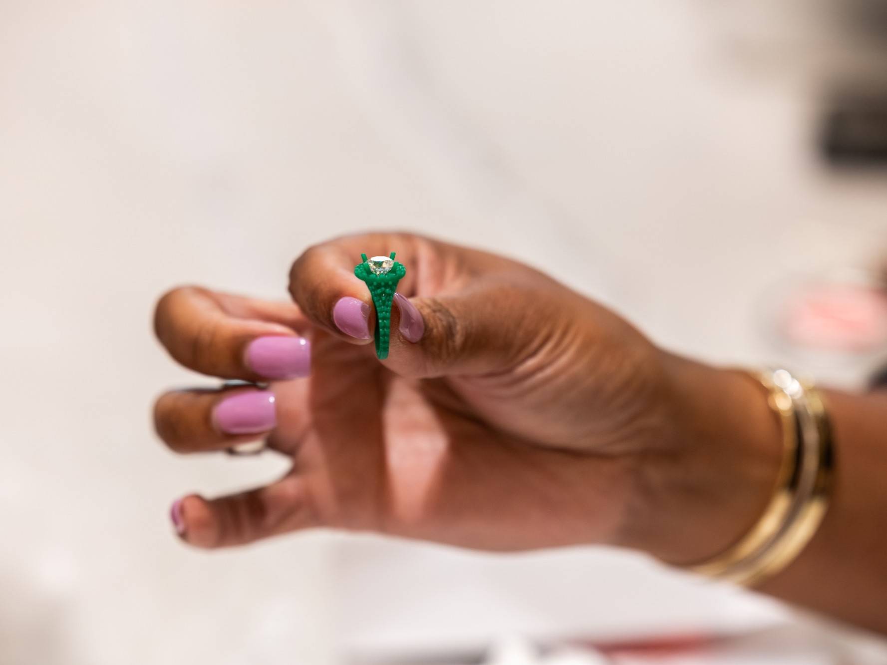 Nicole Williams holding the engagement ring cast with the diamond.