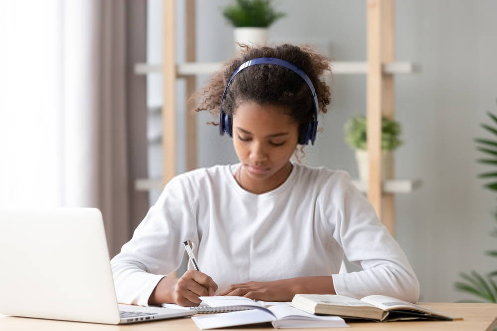 young girl studying with headphones on