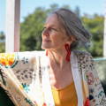Profile picture of an older woman sitting on her porch.