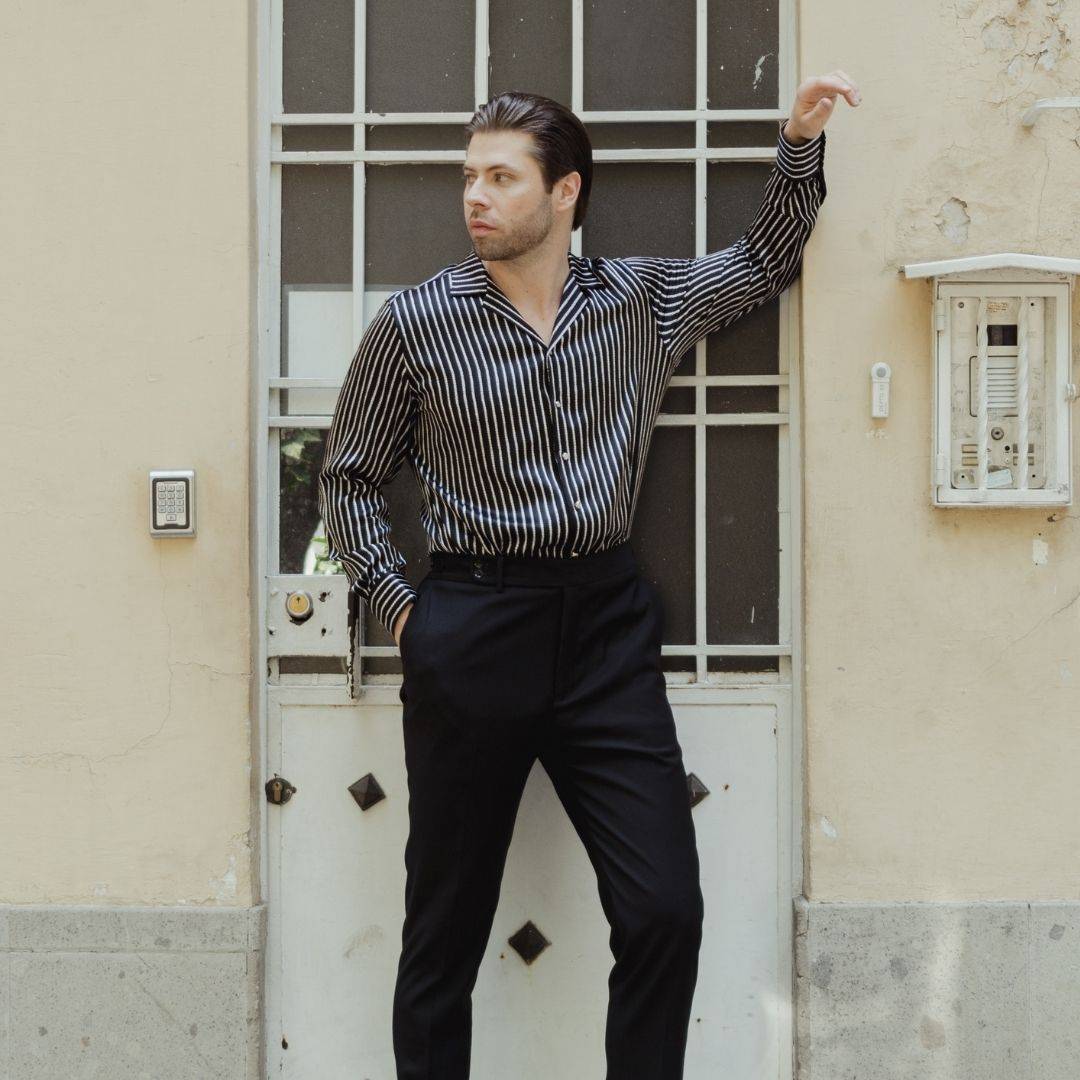 model standing in a doorway wearing black pants and a long sleeve black stripe silk shirt from 1000 kingdoms