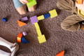 Children playing with colorful wooden blocks on the carpet. 