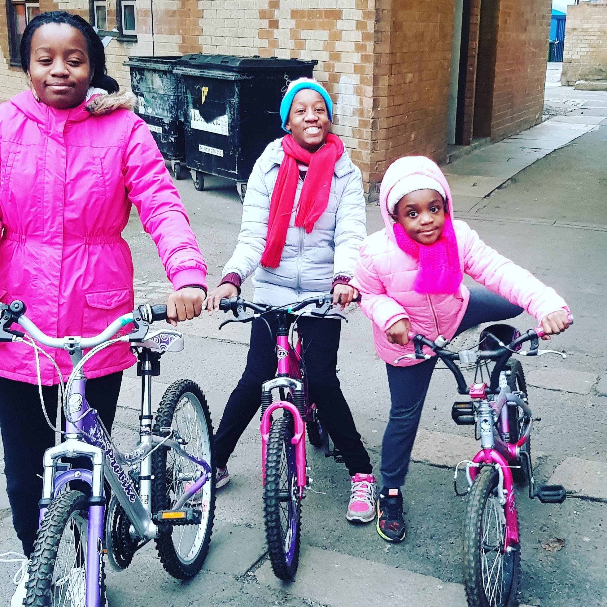 Three young girls with their community bikes