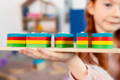 Little girl showing a completed set of Montessori Building Blocks. 