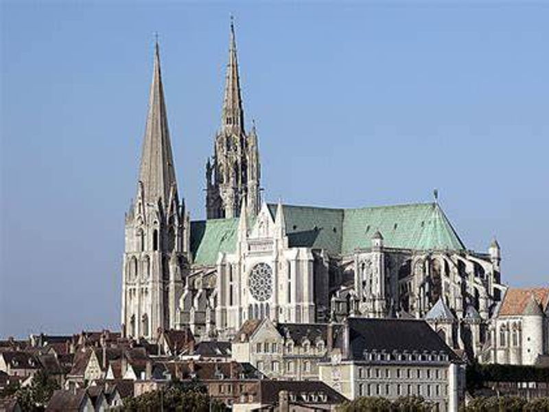 Vue majestueuse de la Cathédrale de Chartres avec ses deux flèches gothiques caractéristiques se découpant dans le ciel bleu