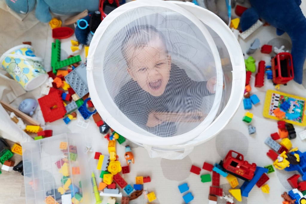 Little boy excited to be standing around various colorful toys.