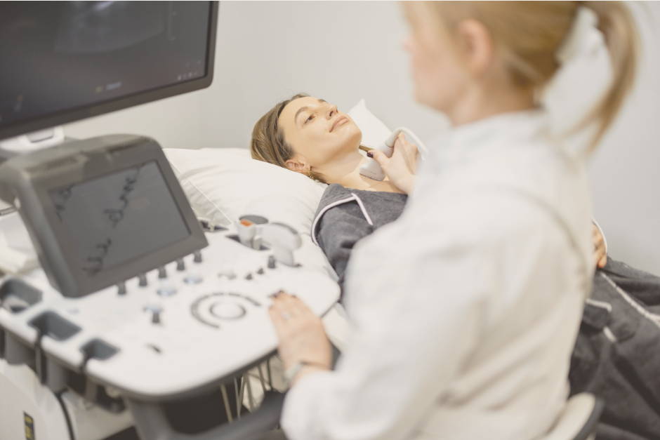 Gynecologist examines thyroid gland with ultrasound