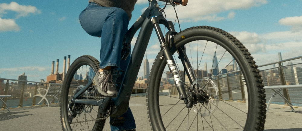 Woman on Specialized electric mountain bike in front of New York City skyline