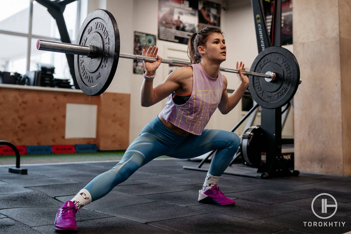 female athlete squatting with barbell