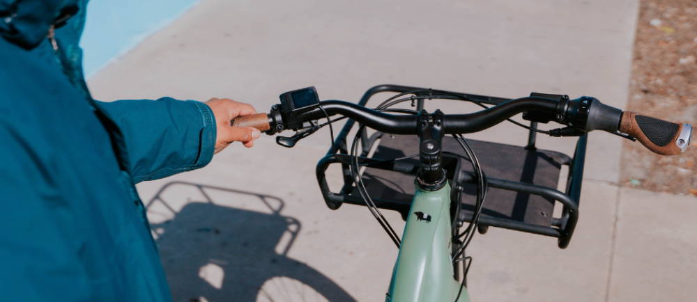 a man with his hand on the handlebars of a green electric bike