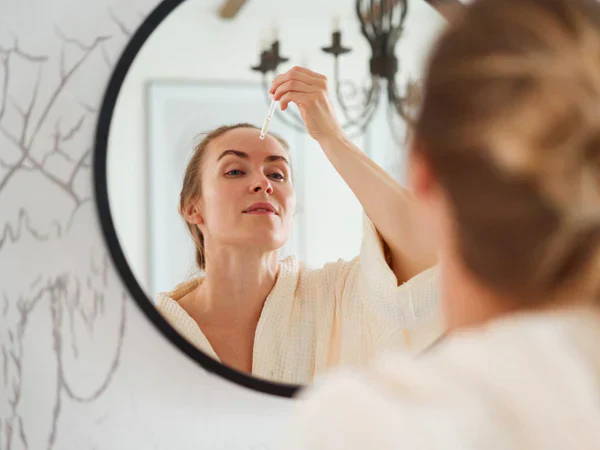woman applying cream on her face