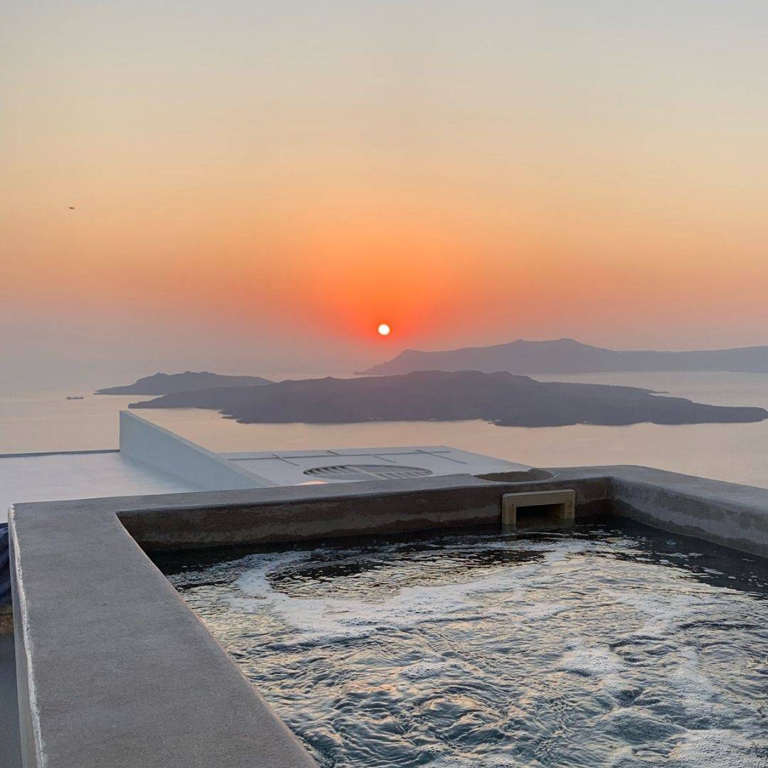 Cavotagoo infinity pool overlooking Santorini caldera at sunset