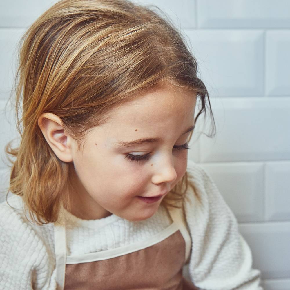 Un petit garçon utilise des couverts enfant pour dresser le couvert