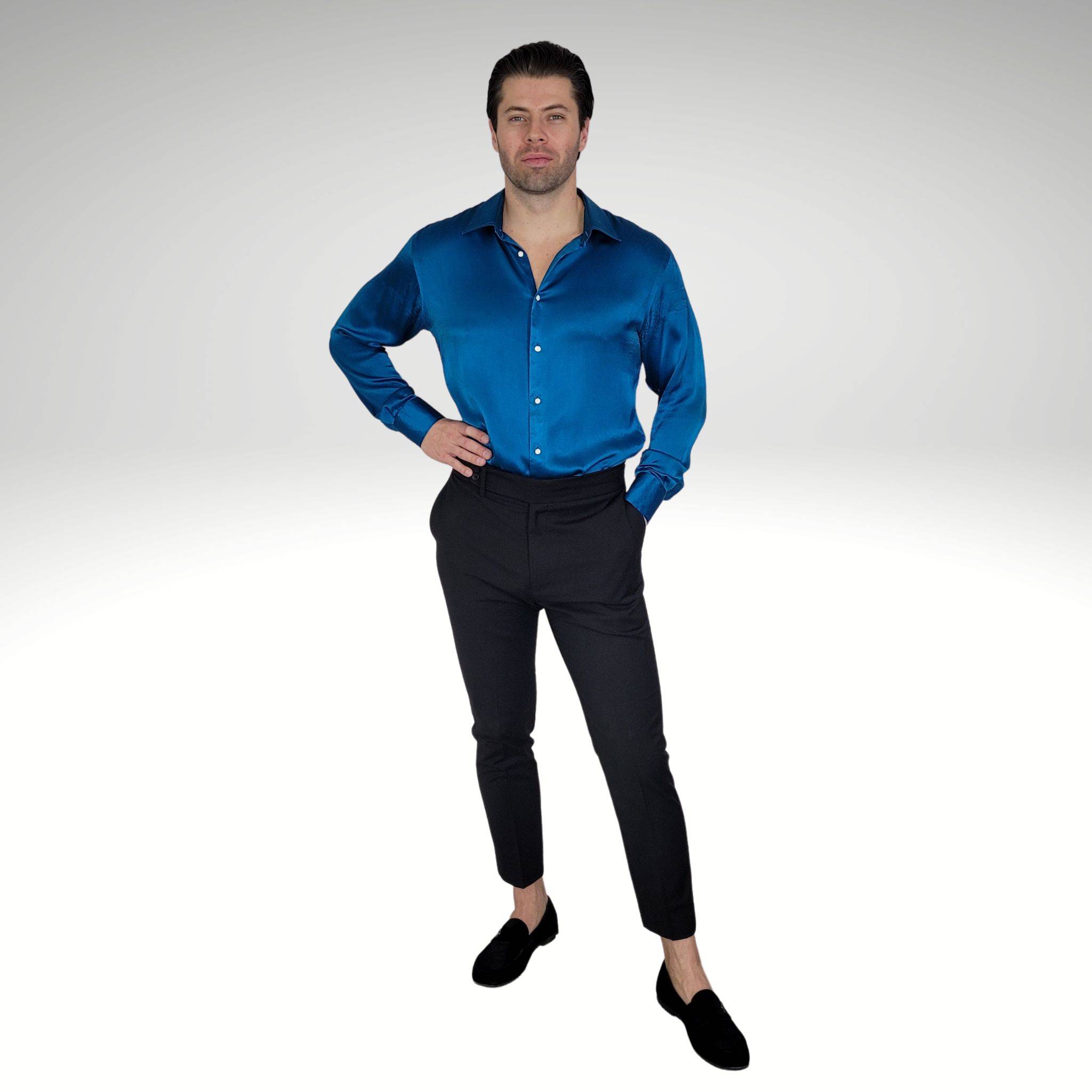 man wearing a turquoise silk shirt and high waisted black pants with black velvet loafers