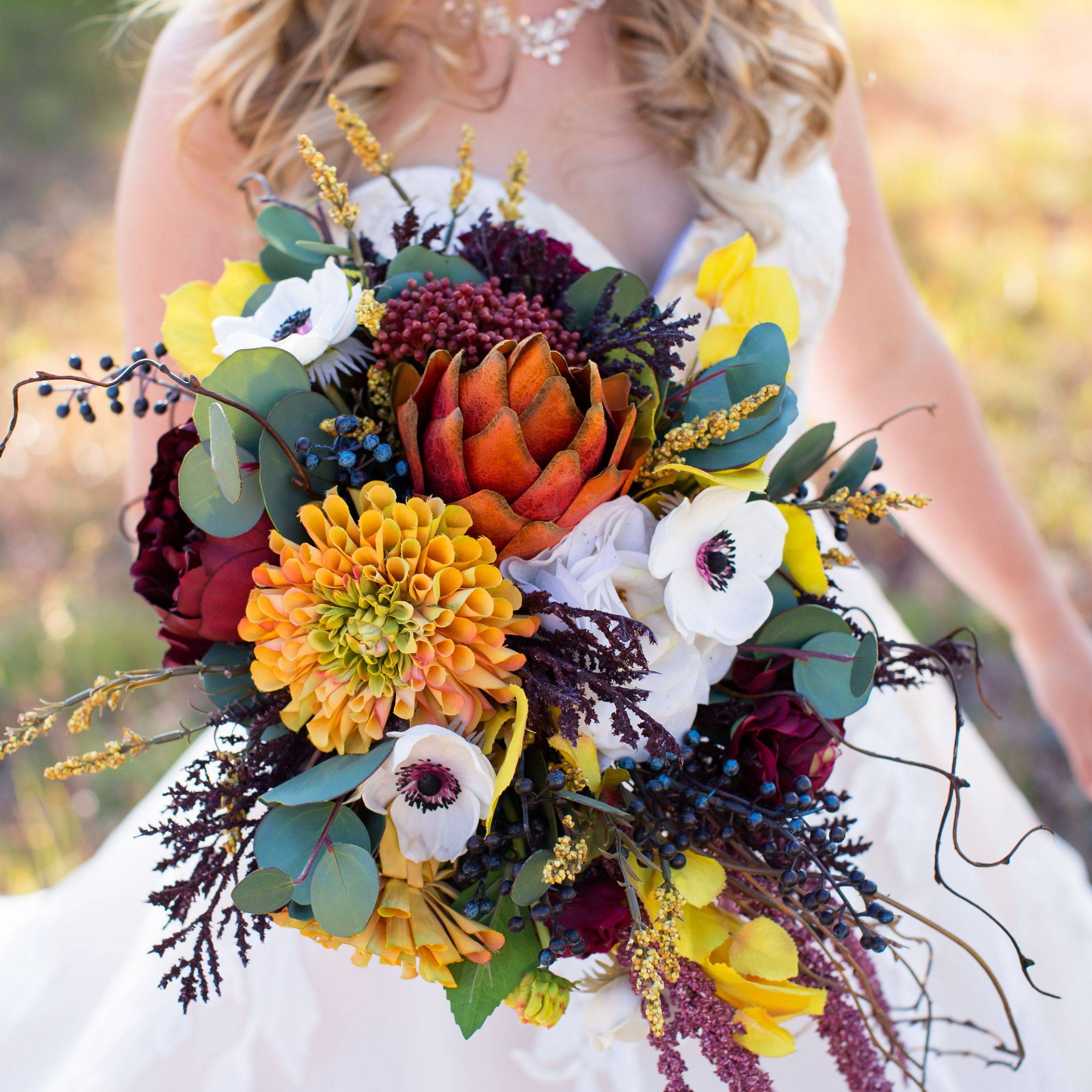 Cascading fall wedding bouquet with mustard dahlias, burgundy peonies, anemones, branches, and silver coin eucalyptus 