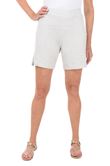 A woman wears a pair of white pull-on cotton shorts.