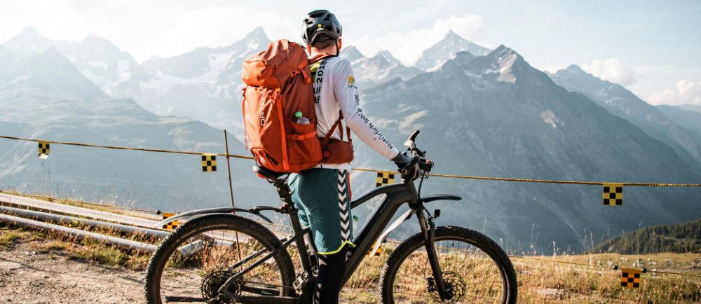 Rider with an electric mountain bike overlooking a mountain range