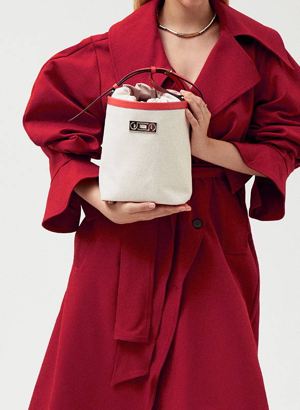 A model delicately holding The Francesca Canvas Bucket in her hands, emphasizing the bag’s elegant design and sophisticated appeal.