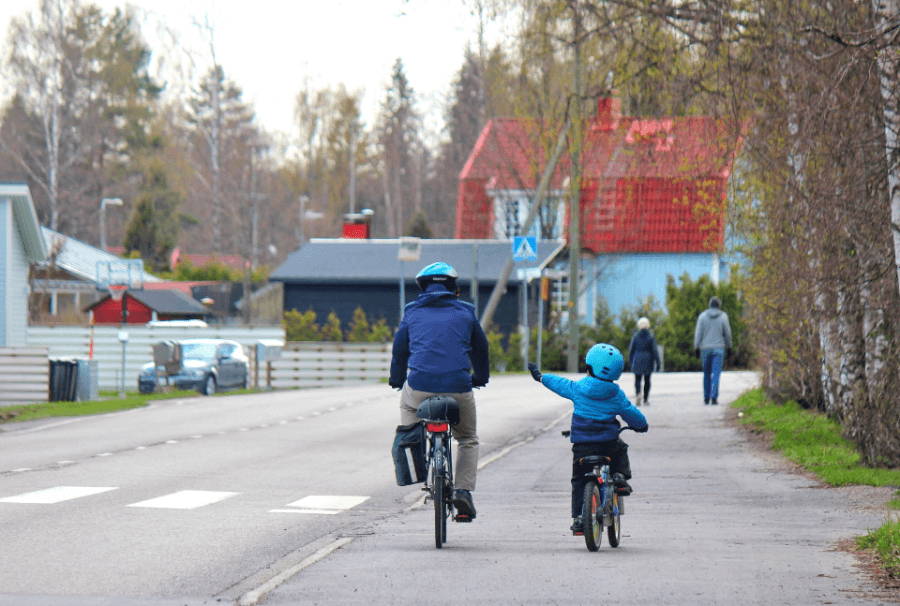 自転車で歩道を走る親子の後ろ姿