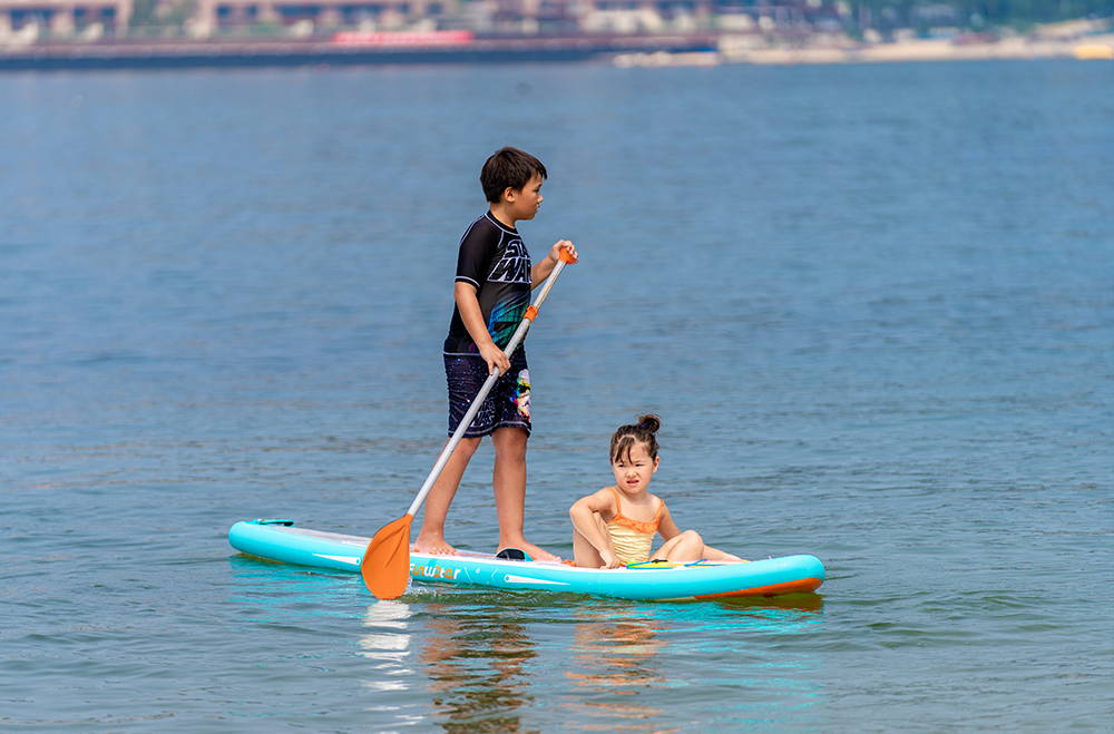 a boy and a girl on paddle board