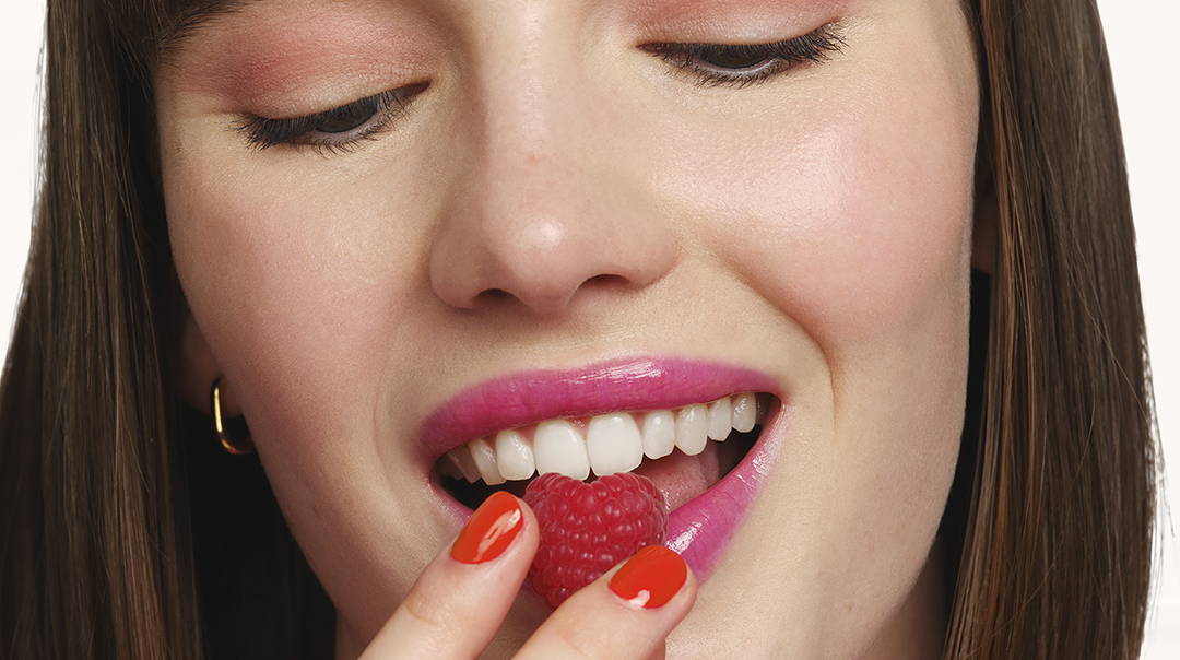 Femme souriante avec un maquillage coloré et rouge à lèvres