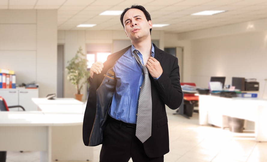 Man in a suit struggling with hyperhidrosis before an interview