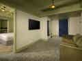 Moderne Suite mit grünem Sofa und direktem Blick in das Schlafzimmer mit Kingsize-Bett.
