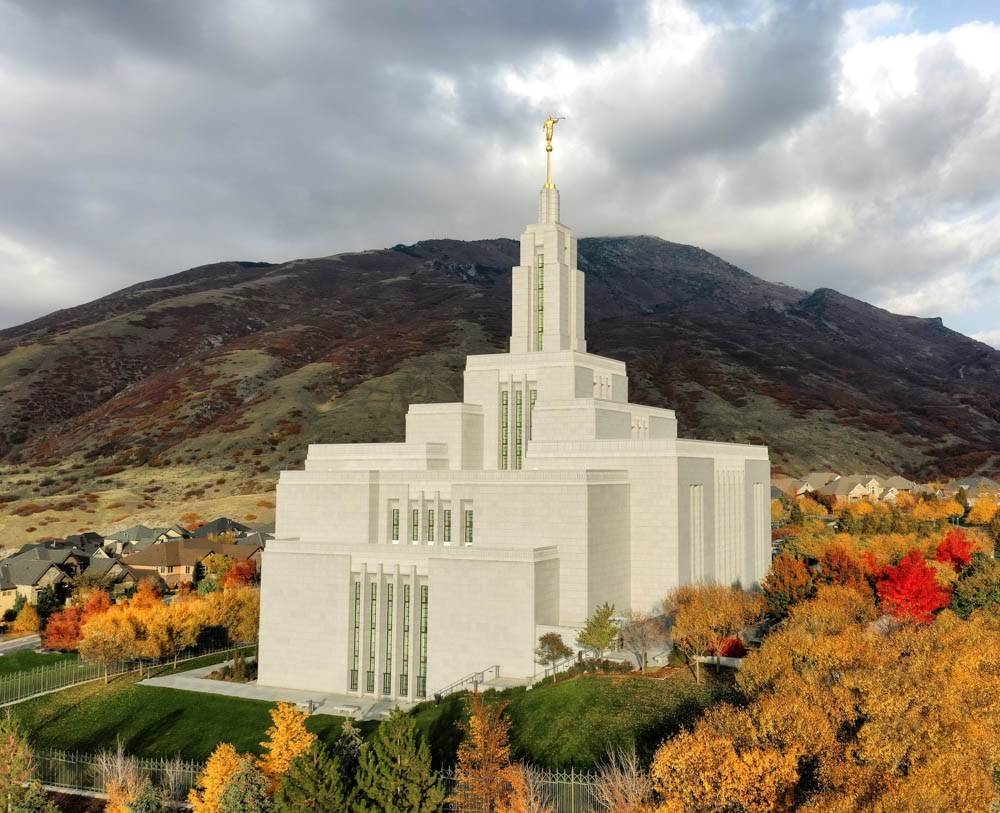 Photo of Draper Temple LDS Temple on a cloudy day amid fall trees. 