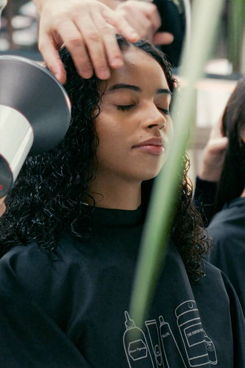 Jonge dame met golvend haar in de avond. Davines krullend haar verzorgen
