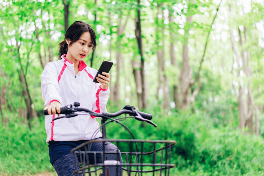 スマホを見ながら自転車に乗る女性