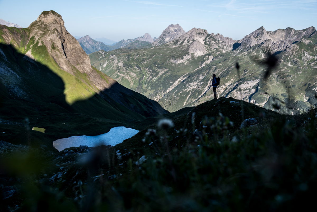 Zwei Wanderer mitten in den Bergen im Kleinwalsertal vor Bergkulisse