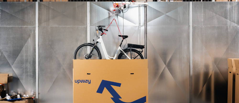 Electric bike being lowered into shipping box