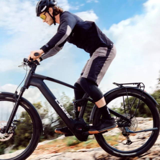 a man riding an electric mountain bike by the ocean