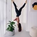 Woman doing a yoga pose upside down at home