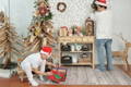 Father and son opening presents and setting up festive decorations in the living room. 