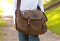 a kid walking down the sidewalk wearing a carrier brief messenger bag