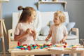 Siblings playing with wooden Montessori toys. 