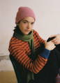 Noia amb un jersei jacquard i una bufanda mirant a la càmera