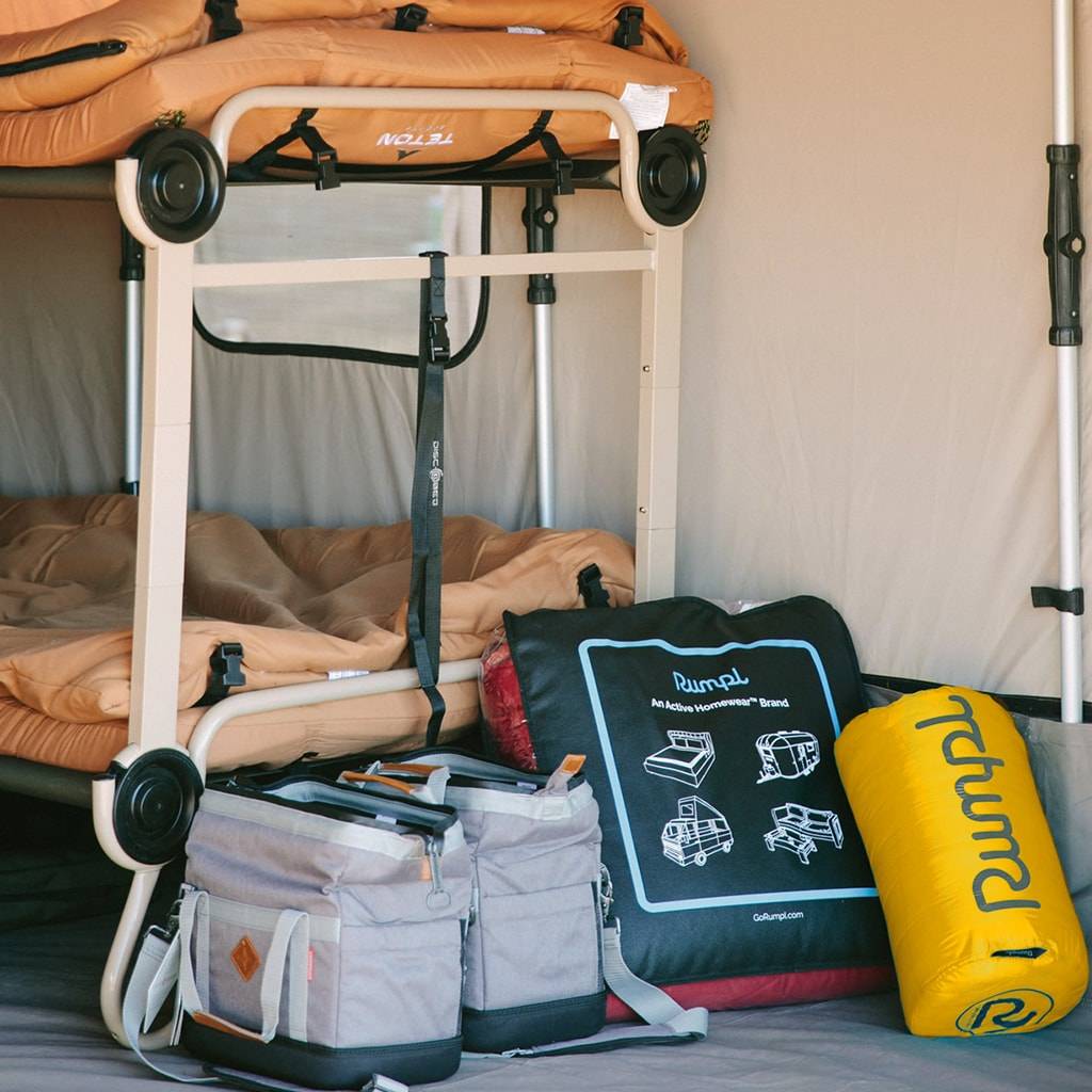 A bunk bed inside a tent with a Yellow Rumpl camping blanket