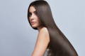 Brown haired woman with sleek frizz free long hair after keratin treatment