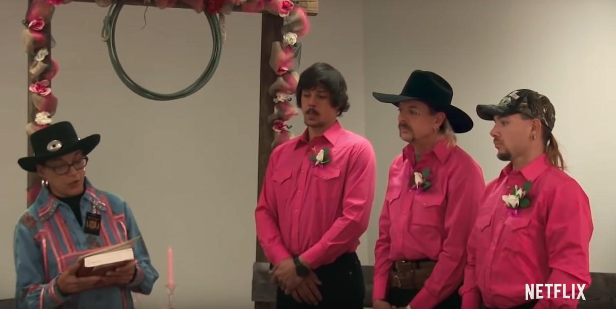 Joe's wedding alongside his two boyfriends all wearing matching outfits being officiated at their wedding.